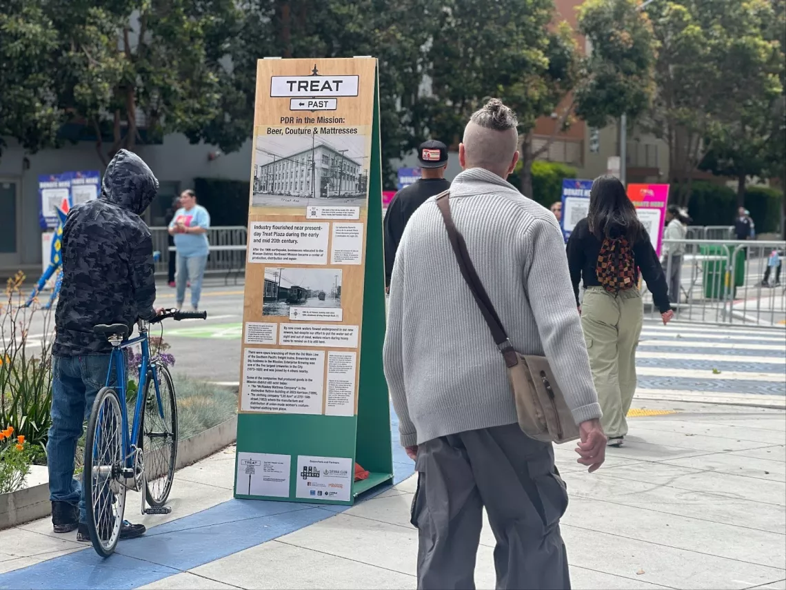 People reading signs and infographics during community outreach
