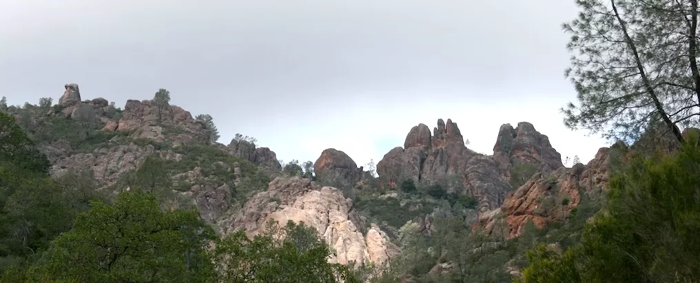 Under gray but clearing sky, rock formations of pinnacles
