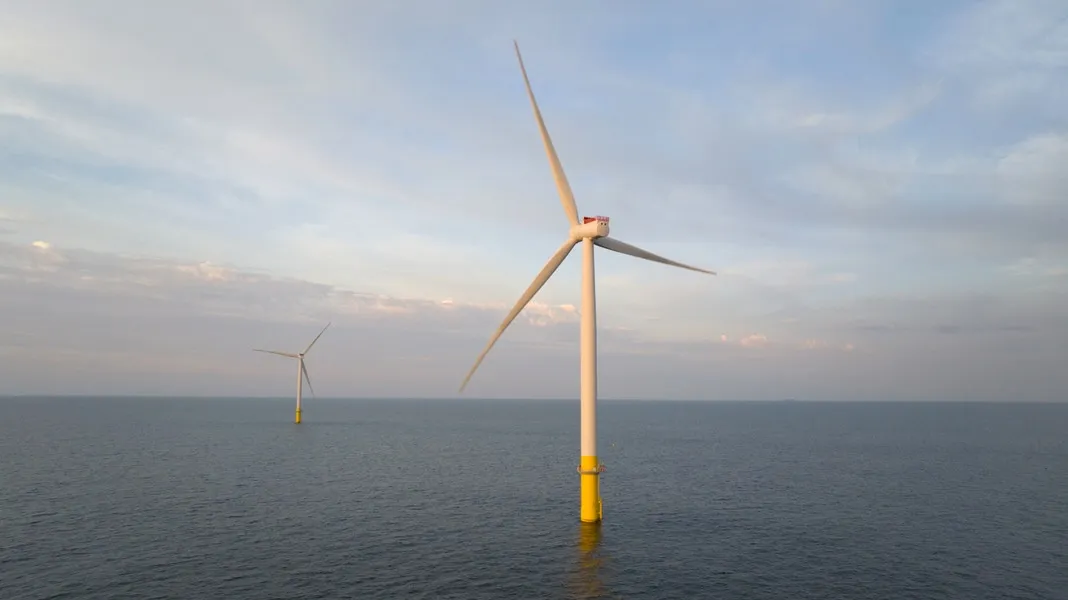 A photograph of two offshore windmills in the open ocean.