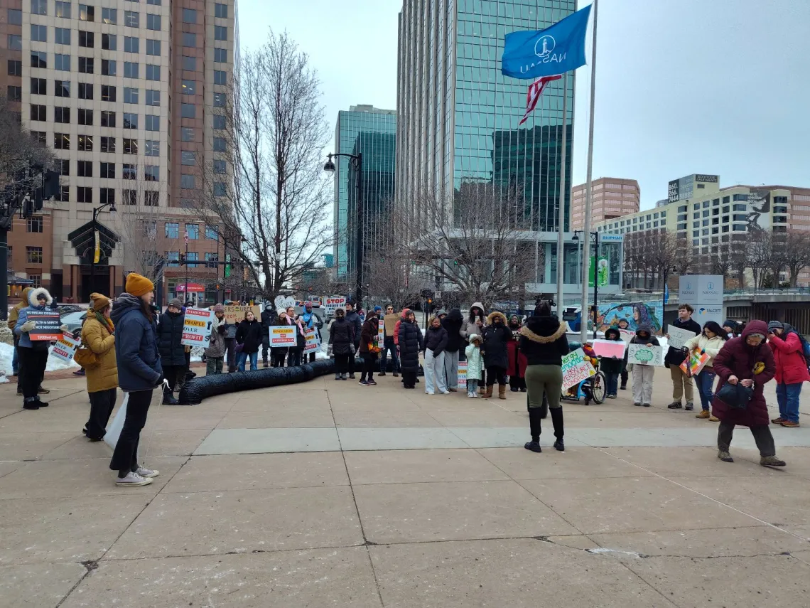 Fifty people with signs gather outside Eversource headquarters for rally.