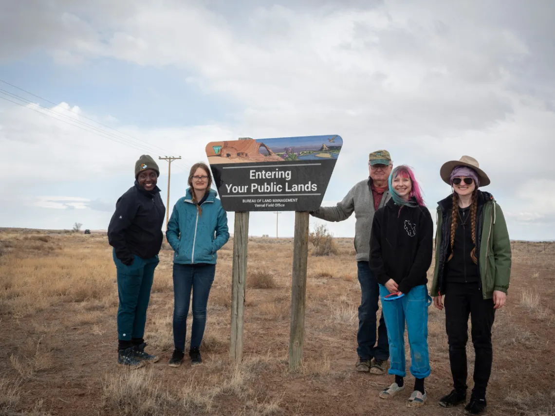A group of people next to a sign that says "Entering Your Public Lands"