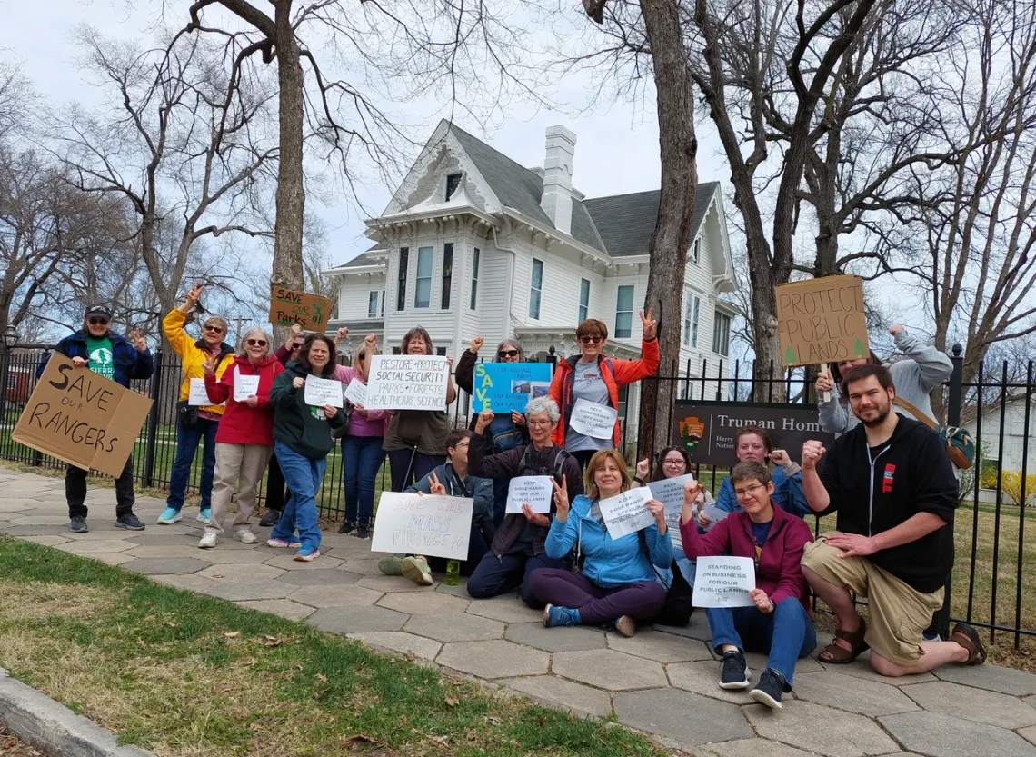 group of people posing with signs