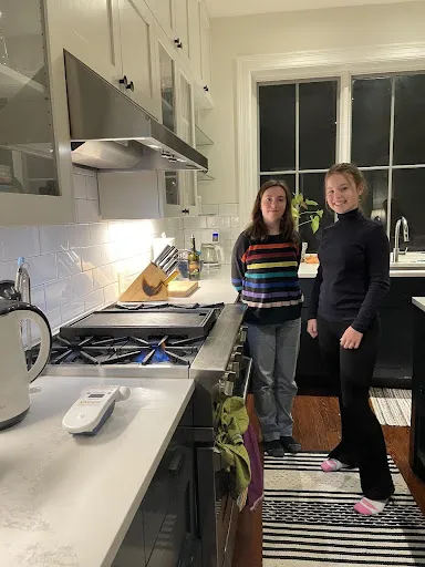 Two students in a kitchen testing a gas stove.