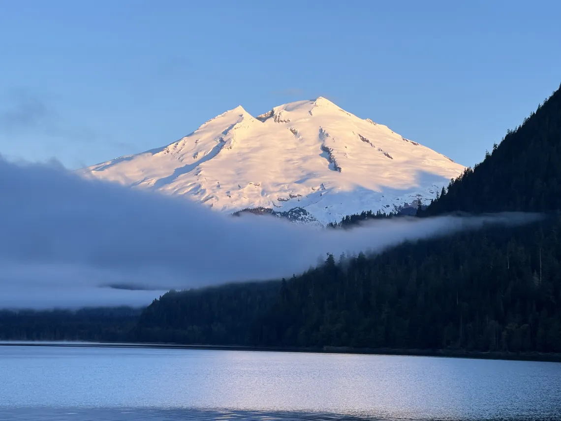 Sunrise over lake with snow-capped mountain in background