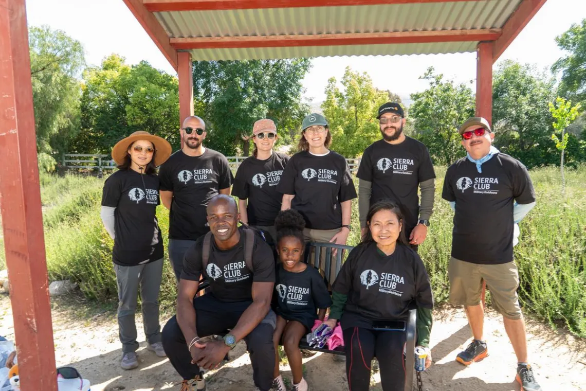 nine people wearing Sierra Club Military Outdoors t-shirts pose for a photo