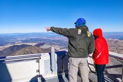 One person at observation deck pointing out something to another person