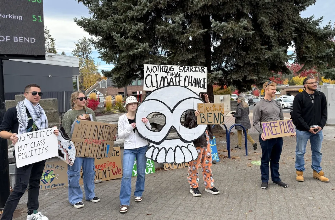 A group of young people at a protest holding signs