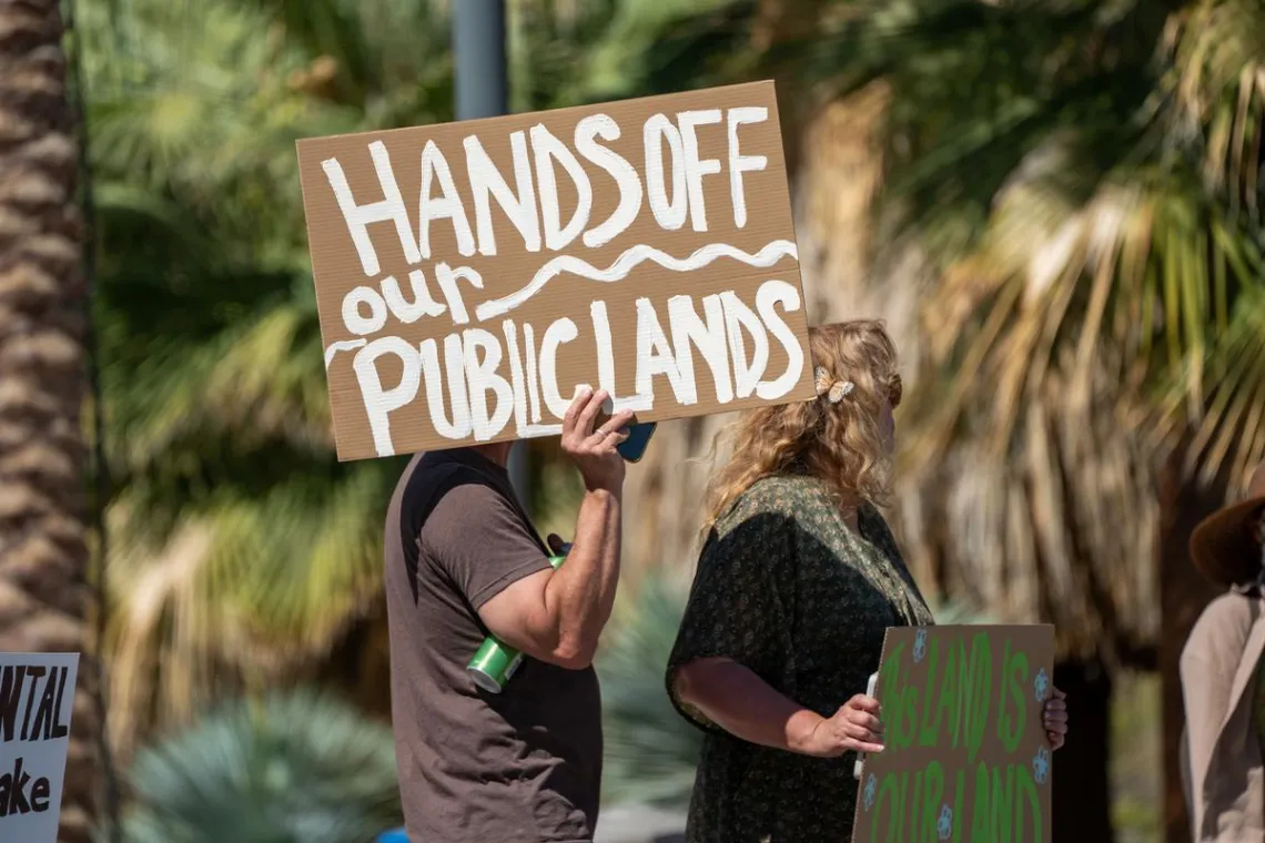 protester with "hands off our public lands" sign