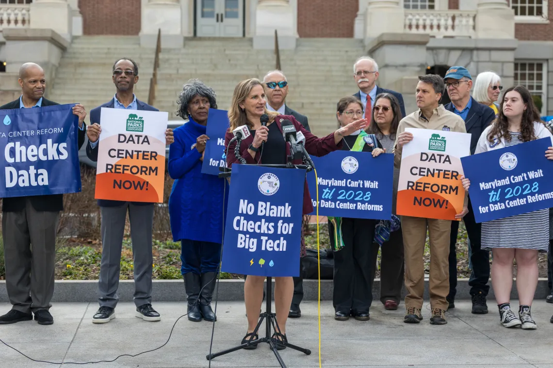 People holding signs at data center rally, 2026