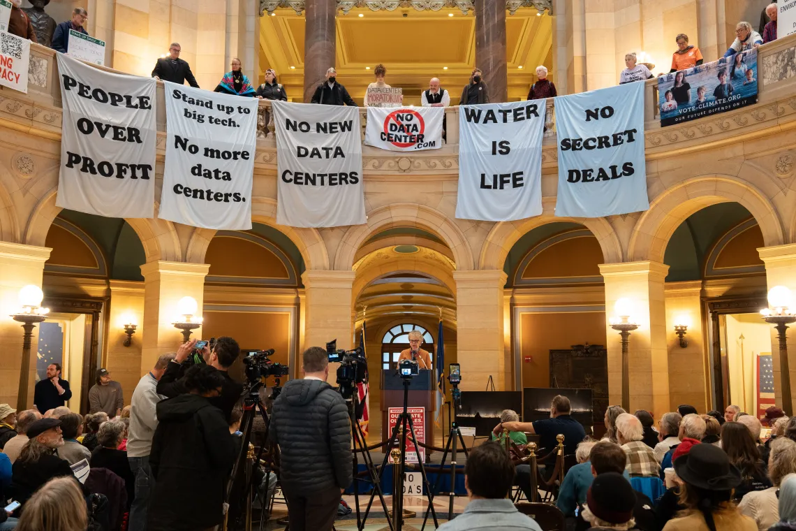 Activists hold banners encouraging accountability for data centers in the Minnesota state capitol rotunda. Photo credit: Devon Young Cupery