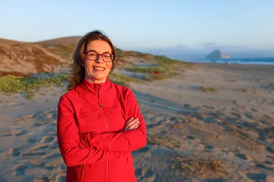 Assemblymember Dawn Addis on a beach with Morro Rock in the background