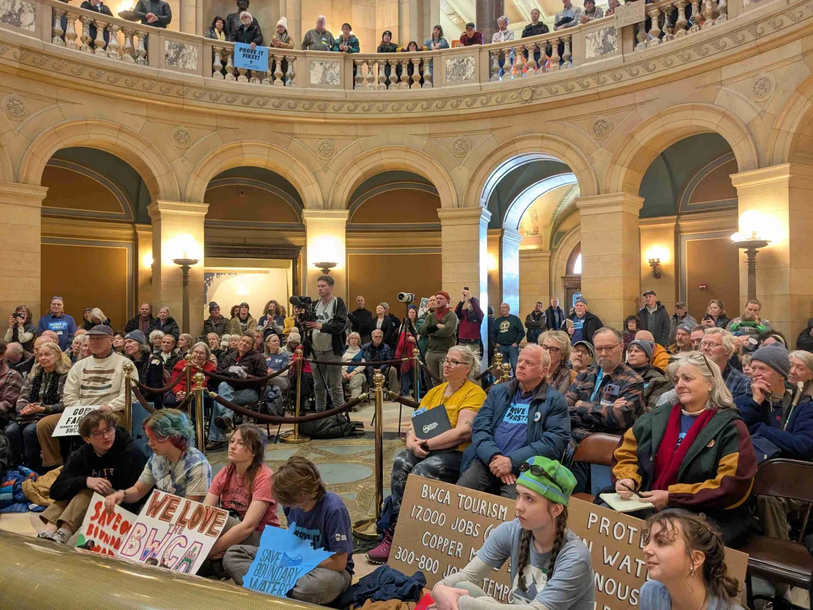 A crowd with signs waiting for a vote.