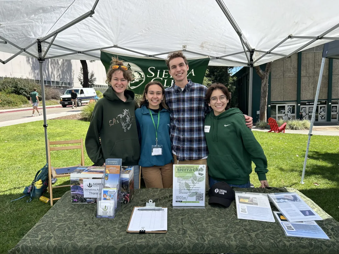 Four students standing at a table with Sierra Club literature