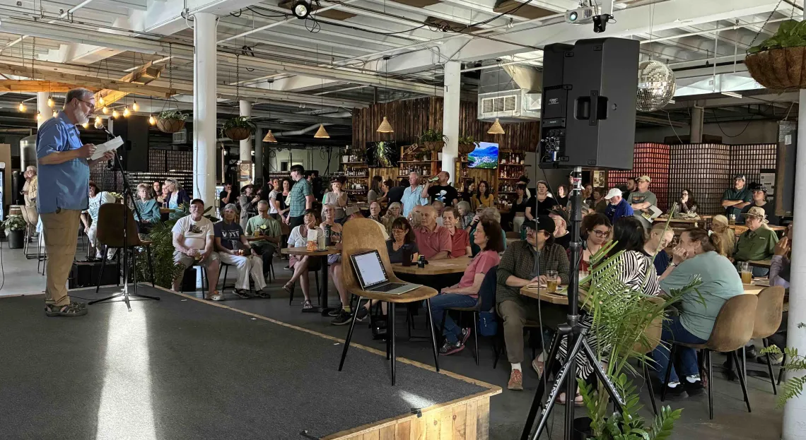 Crowd at the Roadless Rule Rally in Asheville. Sierra Club volunteer, David Reid, is on stage with a microphone. 