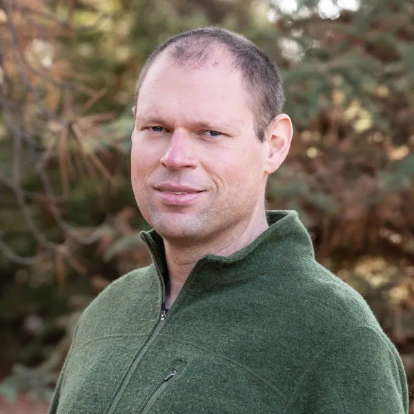 Photo of Adam against a forest background