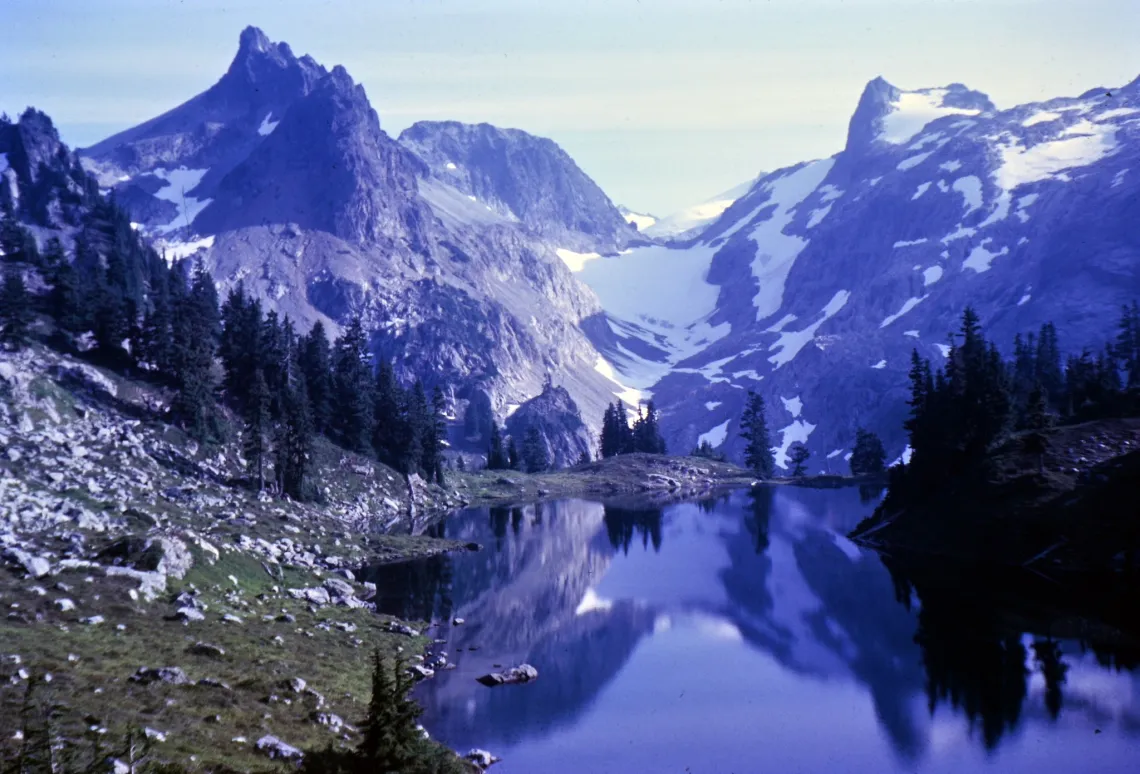 photo of two mountains and an alpine lake, taken circa 1960