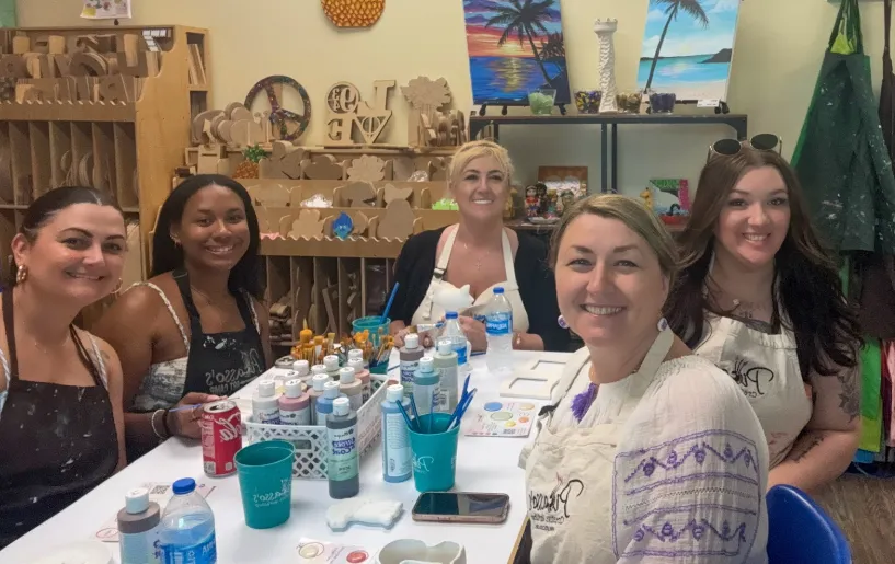 Group of women gathered at a table for ceramics