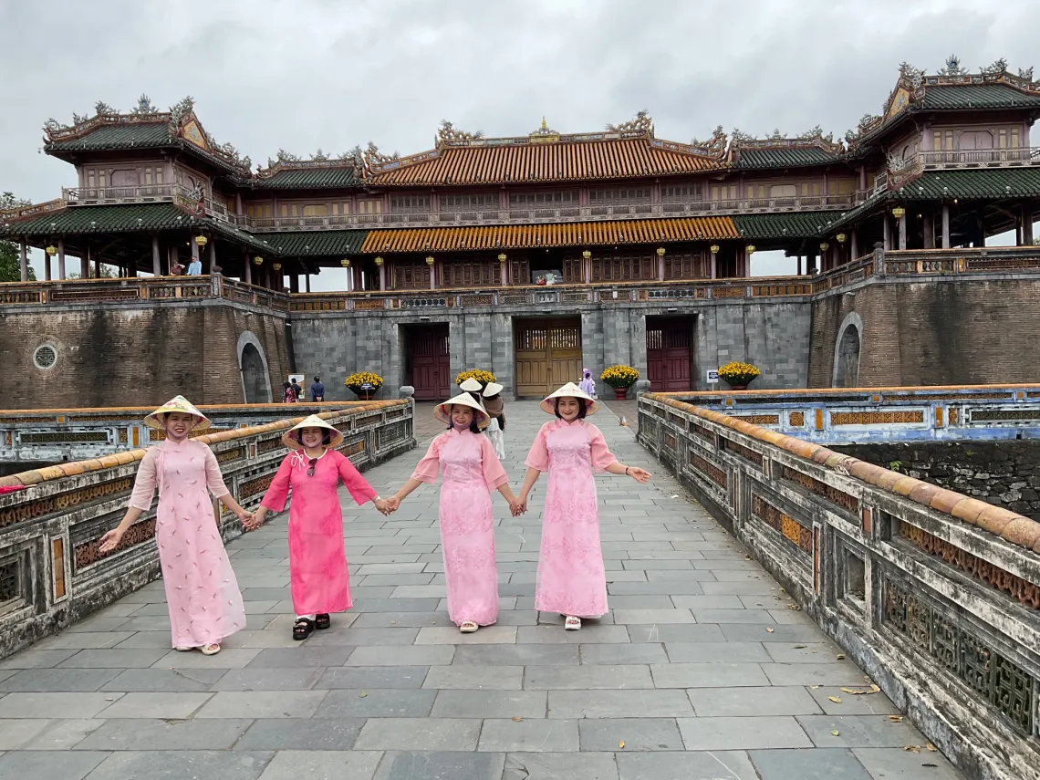 Women in long dresses in front of building