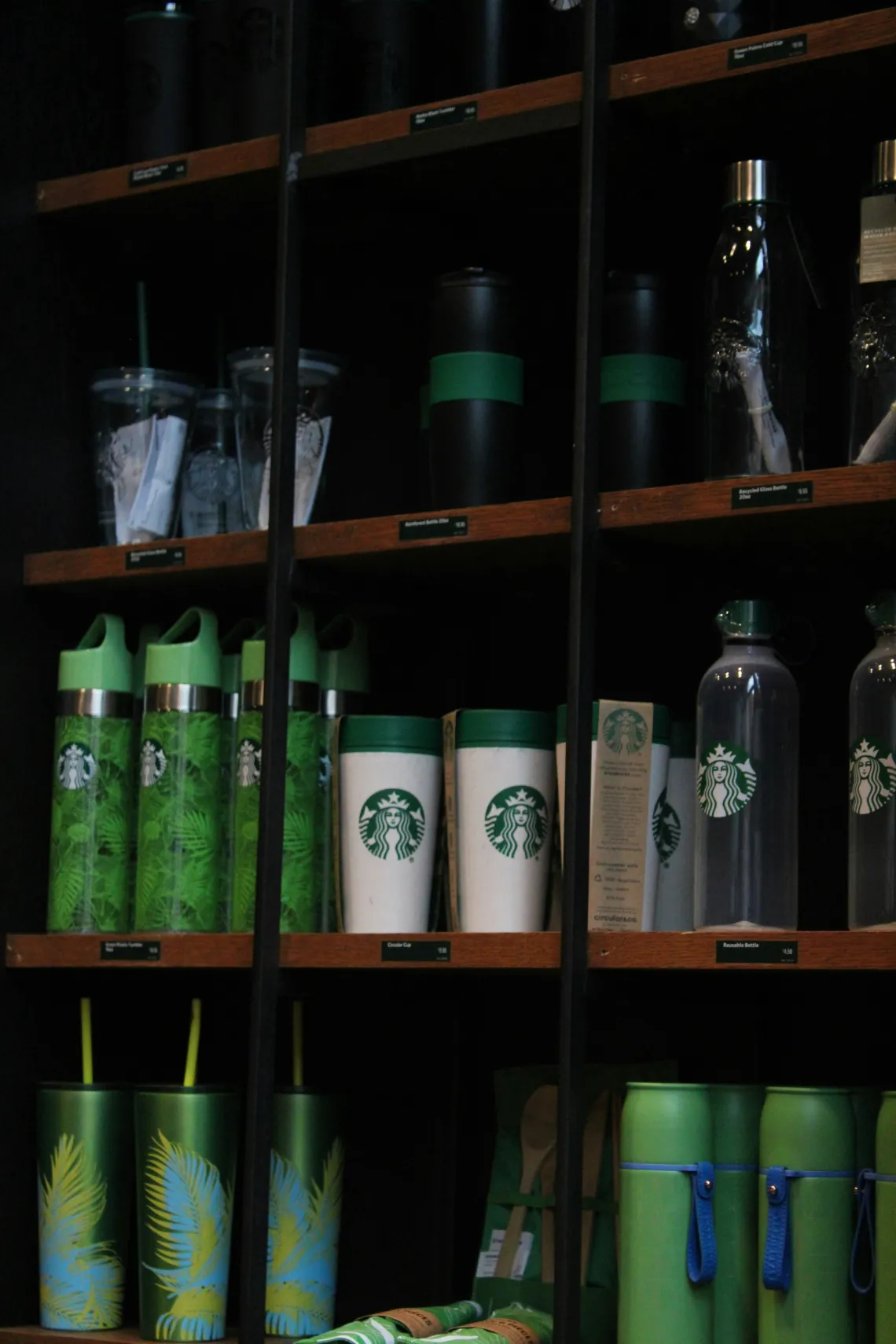 A shelf of starbucks cups and glasses.