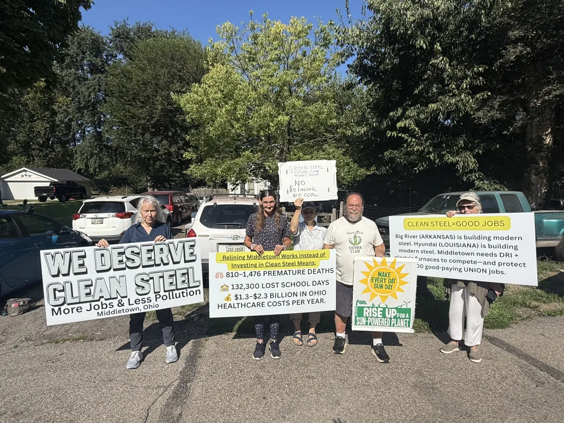 Advocates stand with signs, advocating for clean steel