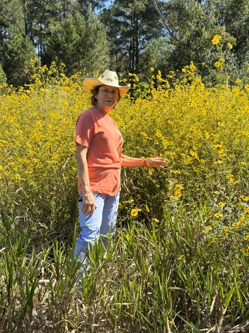 Nancy standing with wildflowers