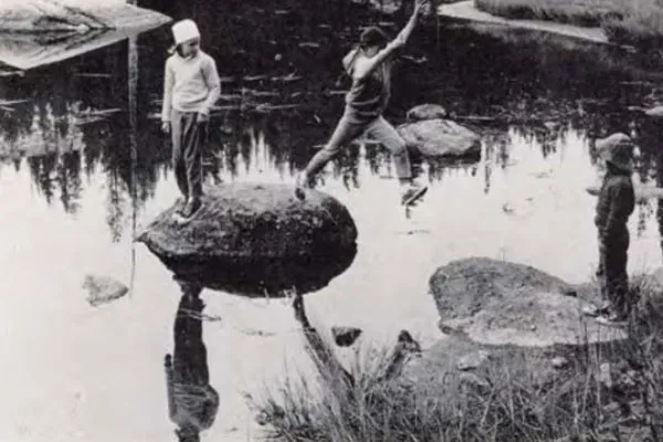 Kids jumping on rocks in a lake