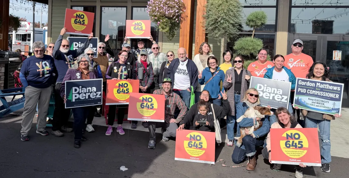 A group of volunteers holding a variety of political signs, most of which say No 645.