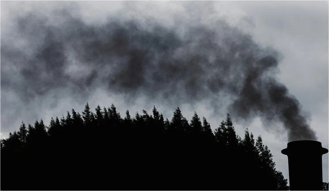 A smokestack releasing black smoke.