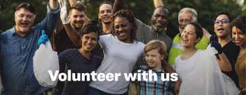 A dozen volunteers gather together holding a bag after an environmental clean up. Words in white in front of the picture say "volunteer with us"