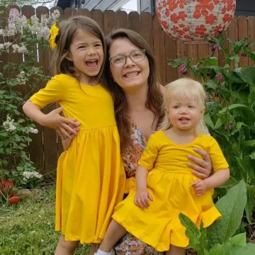 Lisa and her two young girls sitting in a garden