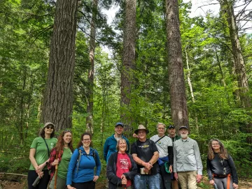 Outings leaders pose for a groups photos under the white pines.