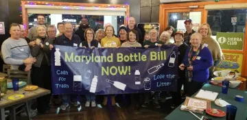 Picture of people holding up banner reading Maryland Bottle Bill Now!