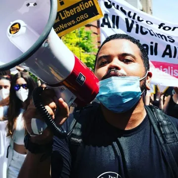 Juan Peralta holds a megaphone and speaks at a rally for justice.
