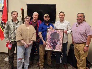 Picture of Julian Matthews and other speakers at the March 2025 Buffalo Summit in Lewiston holding a framed imaged of a buffalo head