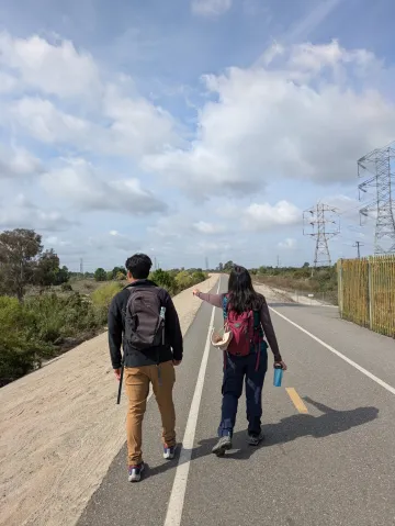 Janelle points out a bird to another hiking companion