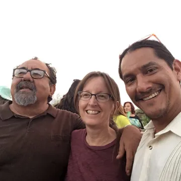 three people smiling and looking at the camera
