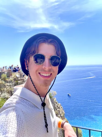 Picture of article's author, Liam Morris who is smiling facing the camera with an oceanside background.