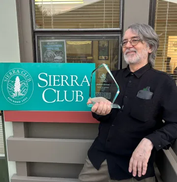 Andrew Christie holding the special recognition award he received from Sierra Club California