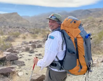 Michael Garcia in the desert with a backpack
