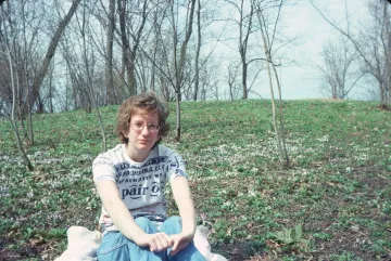 Women sitting on grass with trees in the background