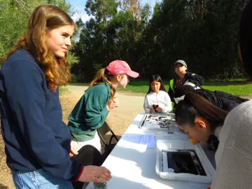 interns helping students use microscopes