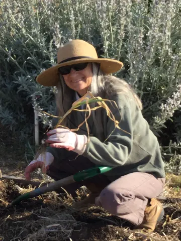 Lindi Doud crouched down to show a plant