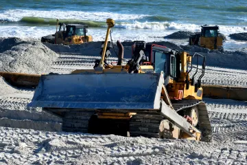 Bulldozer on a beach with ocean in the background
