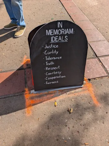 Tombstone sign with a list of values that are being lost - No Kings 3