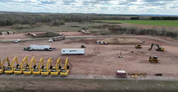 Construction equipment lined up along an open area. Truck labeled with the Michel’s logo.