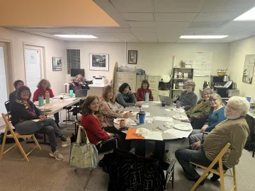 Chapter leaders sitting around tables at their December 2025 meeting