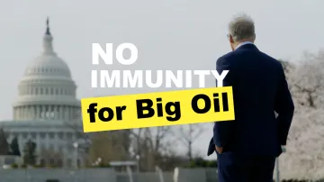 A man standing in front of a DC building with the words "No Immunity for Big Oil" across 