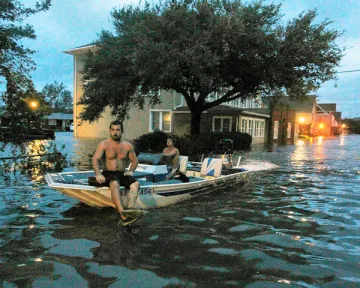 men in boat in flooded town