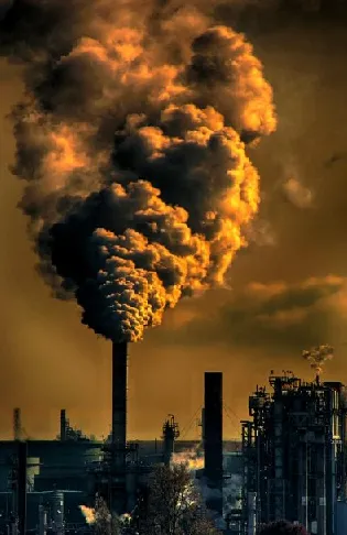 smokestack with smoke billowing with orangish background colors