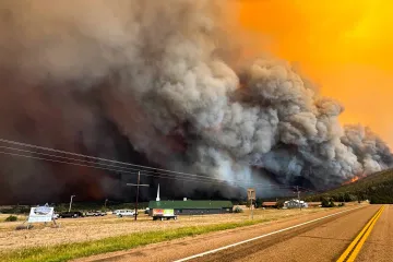 The Aspen Acres wildfire burining with a large gray billow of smoke 